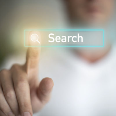 A Caucasian male pressing a search button on a digital screen. A Caucasian male pressing a search button on a digital screen.